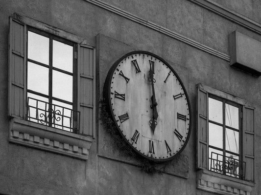 a black and white photo of a clock on a building