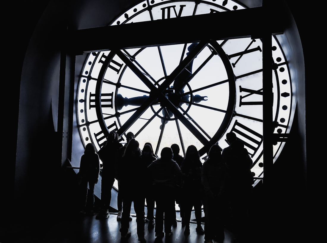 a group of people standing in front of a large clock