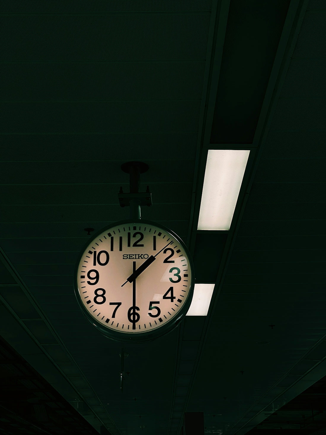 a clock hanging from the ceiling of a building