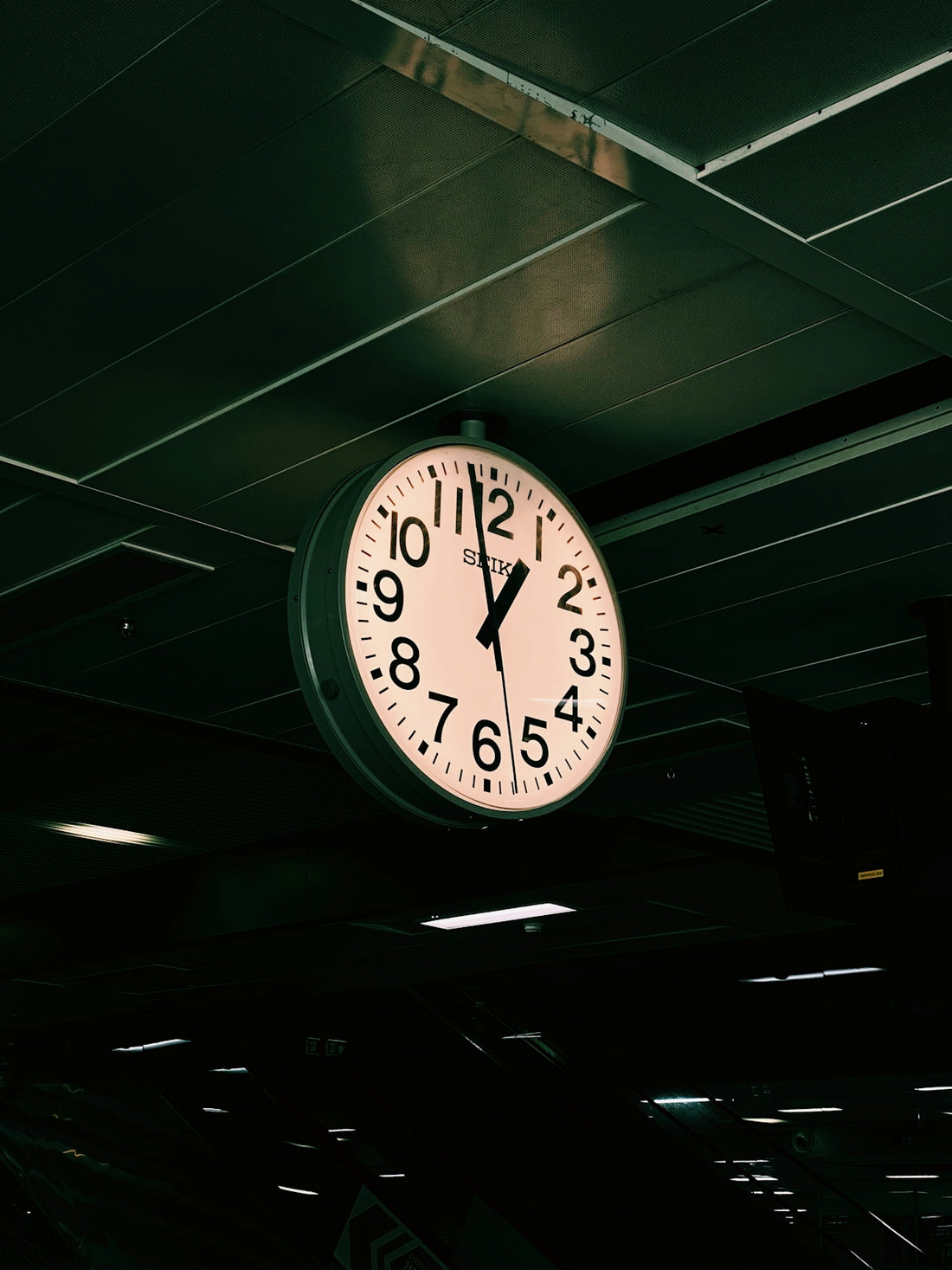 a large clock hanging from the ceiling of a building