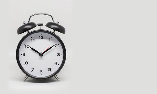 a black and white alarm clock on a white background