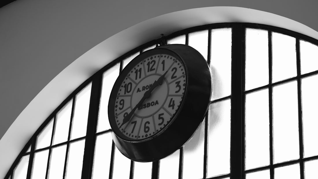 A black and white clock hangs on a wall.