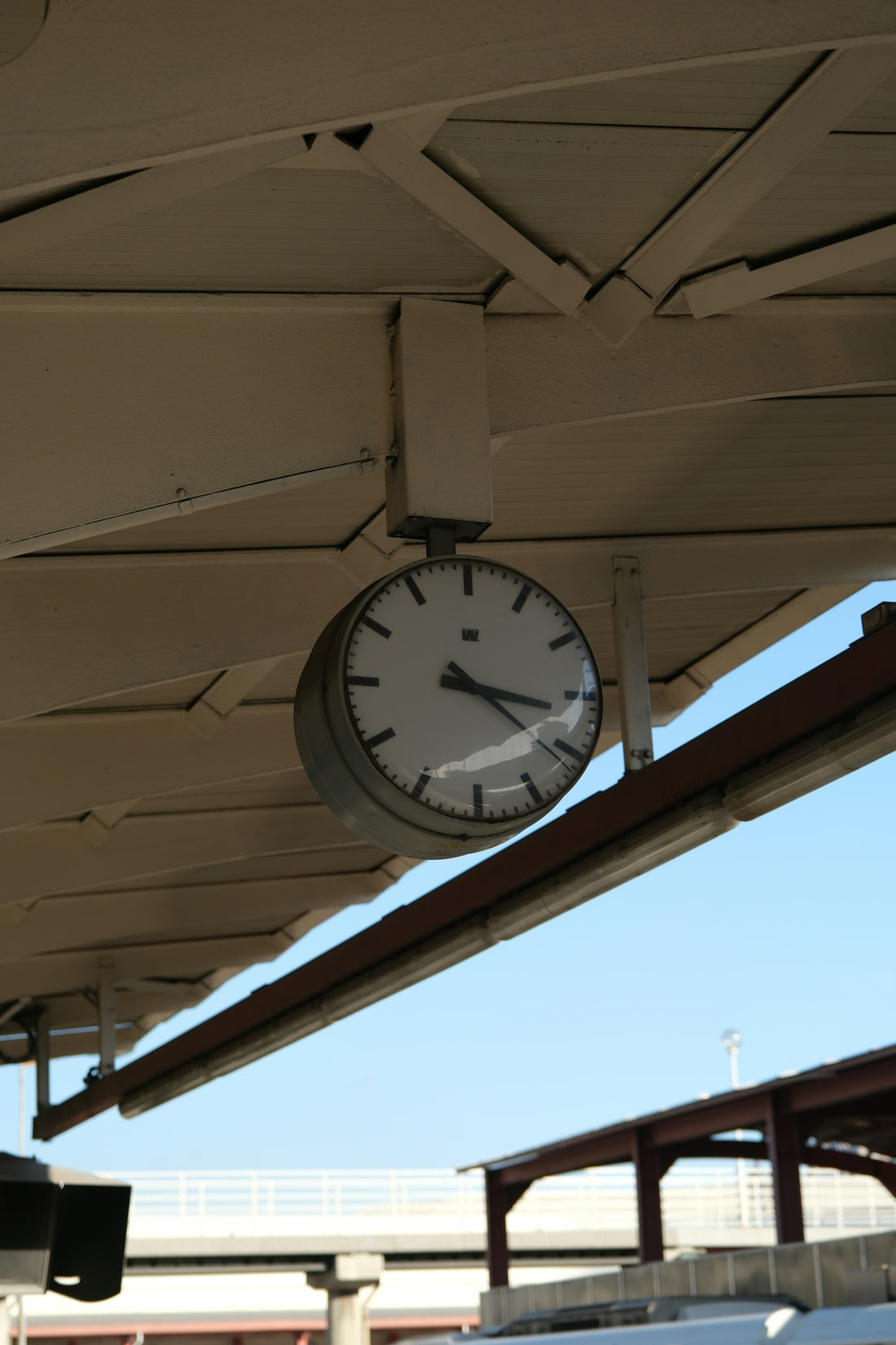 A round clock hangs under a canopy.