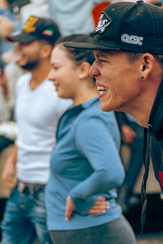 Three people in casual clothing watching something intently.