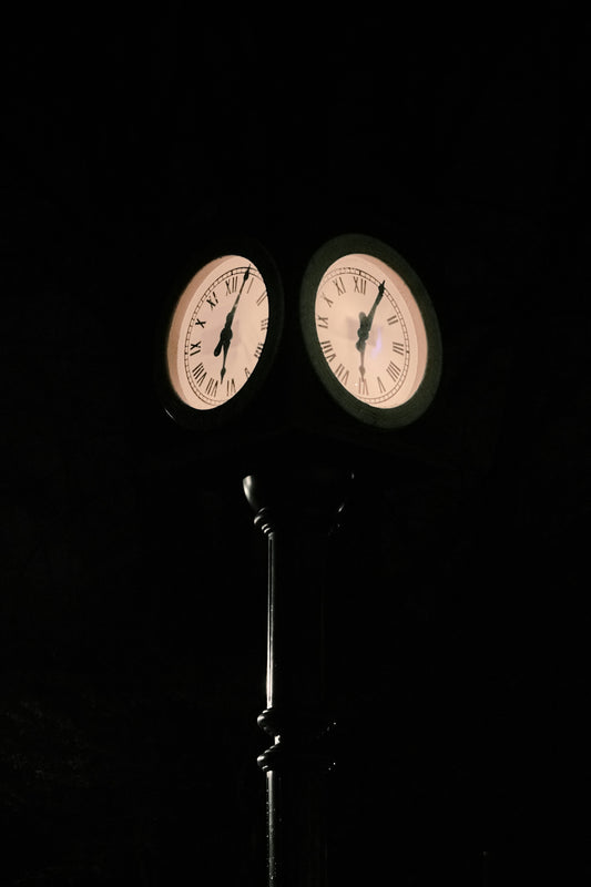 Two illuminated clocks on a dark background